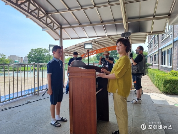 화성시 서신중학교 김향화 교장선생님이 이현우군에게 상장 전달식 촬영을 진행하고 있다. (사진=김경순)