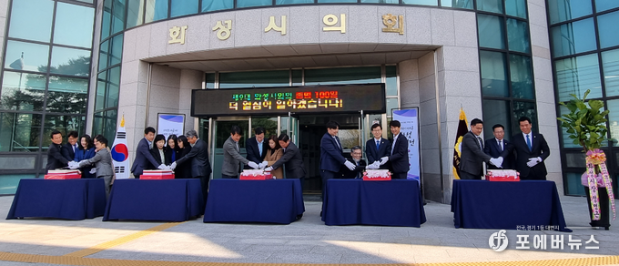 화성시의회가 21일 제9대 화성시의회 출범 100일 맞이 사진전을 자축하며 떡케익 절단식을 진행하고 있다. (사진=김경순)