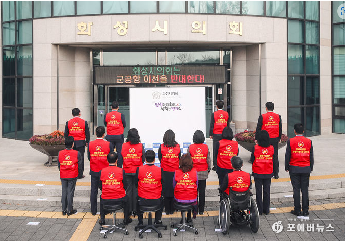 화성시의회 전체의원들이 의회 청사앞에서 ‘수원군공항 이전 및 경기남부통합국제공항 건설' 특별법 추진 행위 강력 철회 퍼포먼스를 진행하고 있다. (사진=김경순)