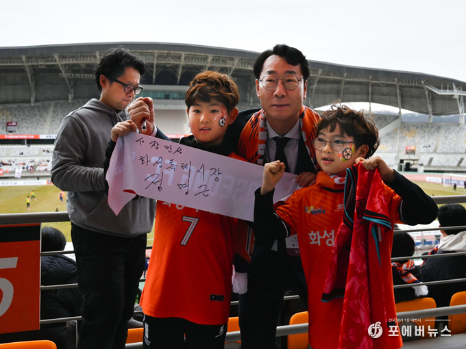 화성FC 구단주 정명근 화성특례시장이 학생들에게 싸인과 유니폼을 선사후 기념촬영을 하고 있다.(사진=김경순)