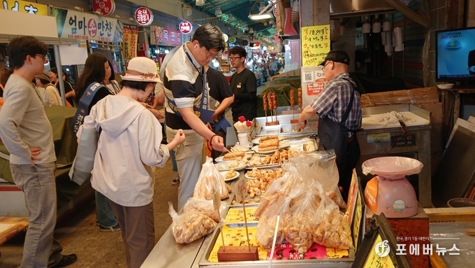 경상원이 안양 중앙시장의 한 점포에서 식품을 구매하고 있다.