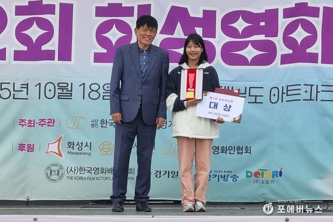 한국영화인협회 경기도화성지부 우호태 집행위원장아 18일 제2회 화성영화제에서 '오피스 좀비' 이정하 배우/감독에게 대상 수상을 기념하고 있다. (사진=김경순)