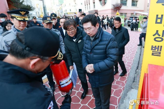 이상일 용인특례시장이 30일 문정중학교 후문에 설치된 안심 비상벨과 비상소화장치를 살펴보고 소화기 사용법에 대한 설명을 듣고 있다