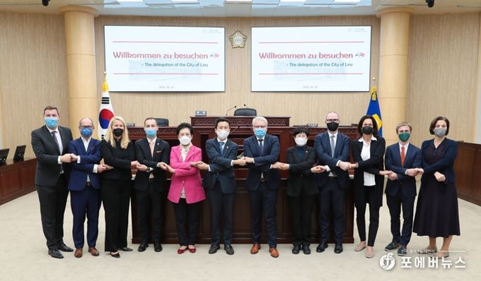 안산시의회 의원들이 27일 의회를 방문한 오스트리아 린츠시 대표단을 접견했다. 사진은 본회의장에서 기념촬영에 임하고 있는 의원들과 대표단의 모습.