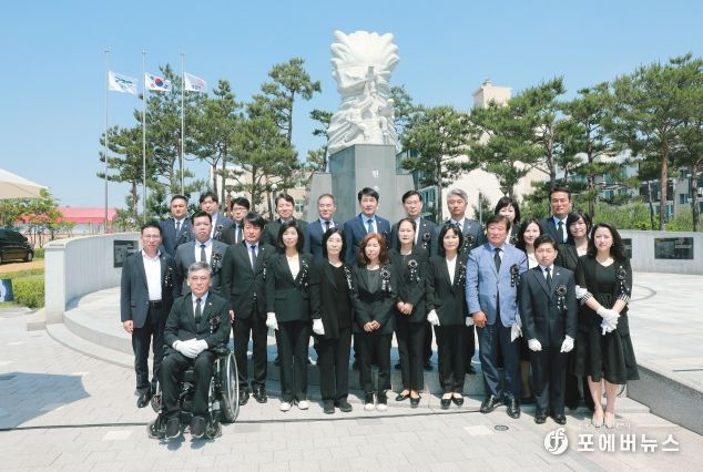 화성시의회 의원 일동이 현충탑 앞에서 단체사진을 찍고 있다.