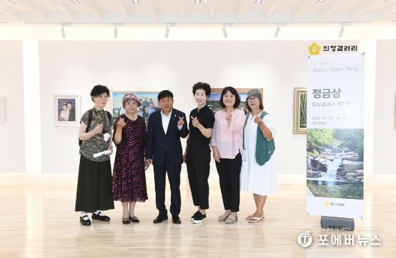 윤창철 의장과 정금상 작가를 비롯한 한국미술협회 양주지부 소속 작가들이 작품을 배경으로 기념촬영을 하고 있다.