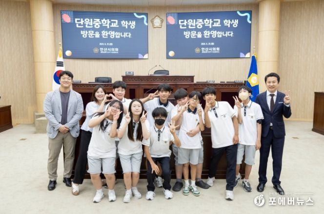 이날 기념촬영에 임하고 있는 단원중학교 학생들과 인솔교사, 의원들의 모습.