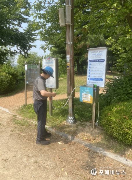 한 시민이 서호공원에 설치된 해충기피제분사기를 사용하고 있다.