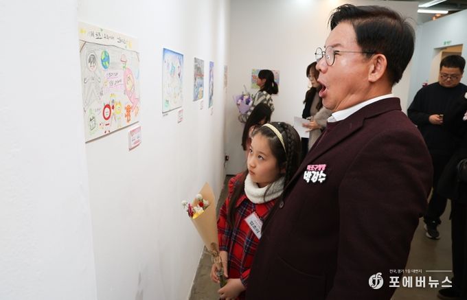 박강수 마포구청장이 수상 어린이와 함께 전시된 그림을 살펴보고 있다.