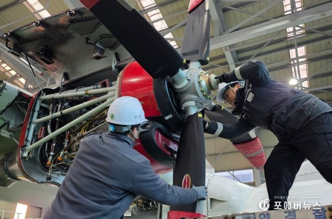 고정익 항공기 프로펠러를 교체중인 해양경찰관